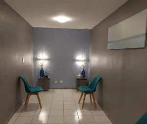 Salle d'attente moderne avec deux chaises bleues et décoration épurée.